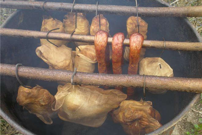 Мясо и сало на палках в коптильне